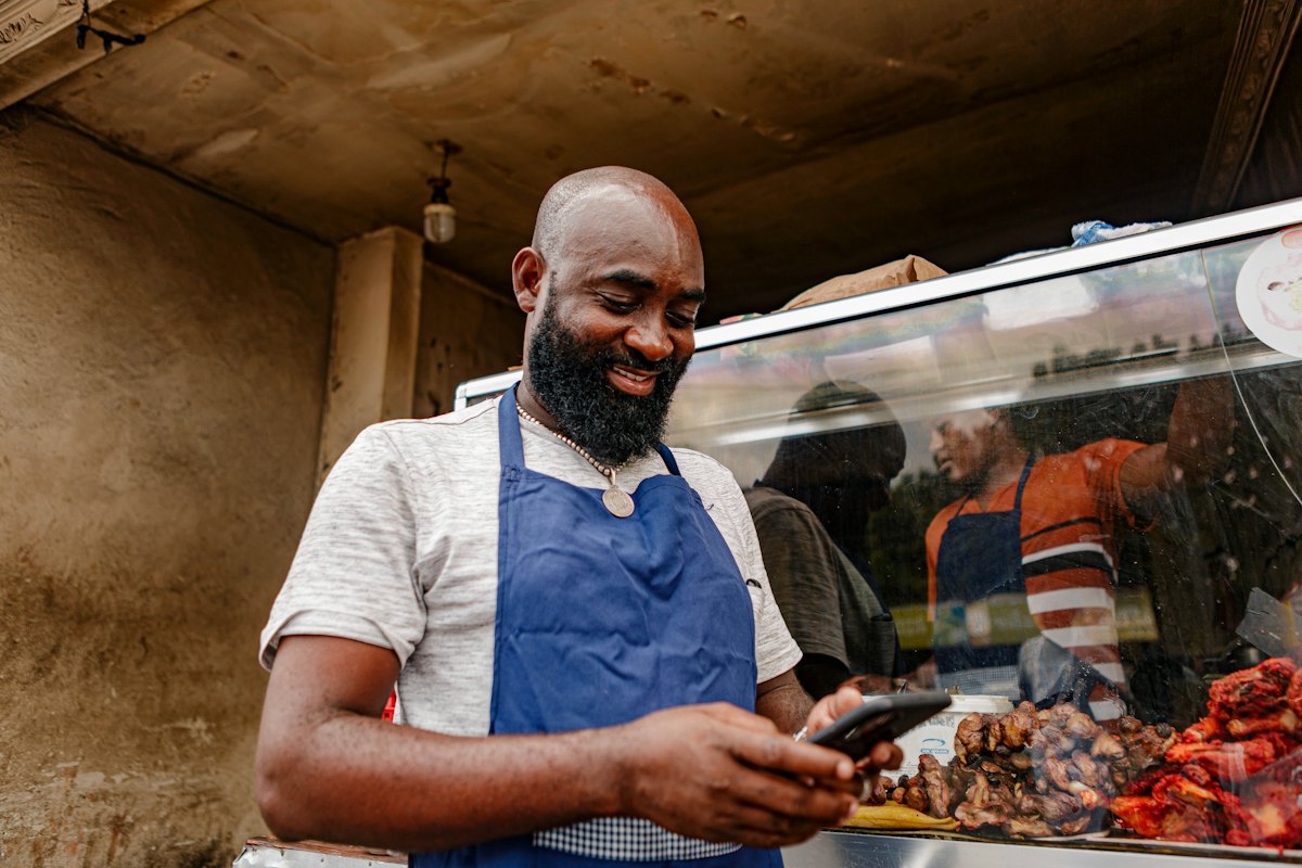 A shop owner checking his Nhimbe workspace on his phone